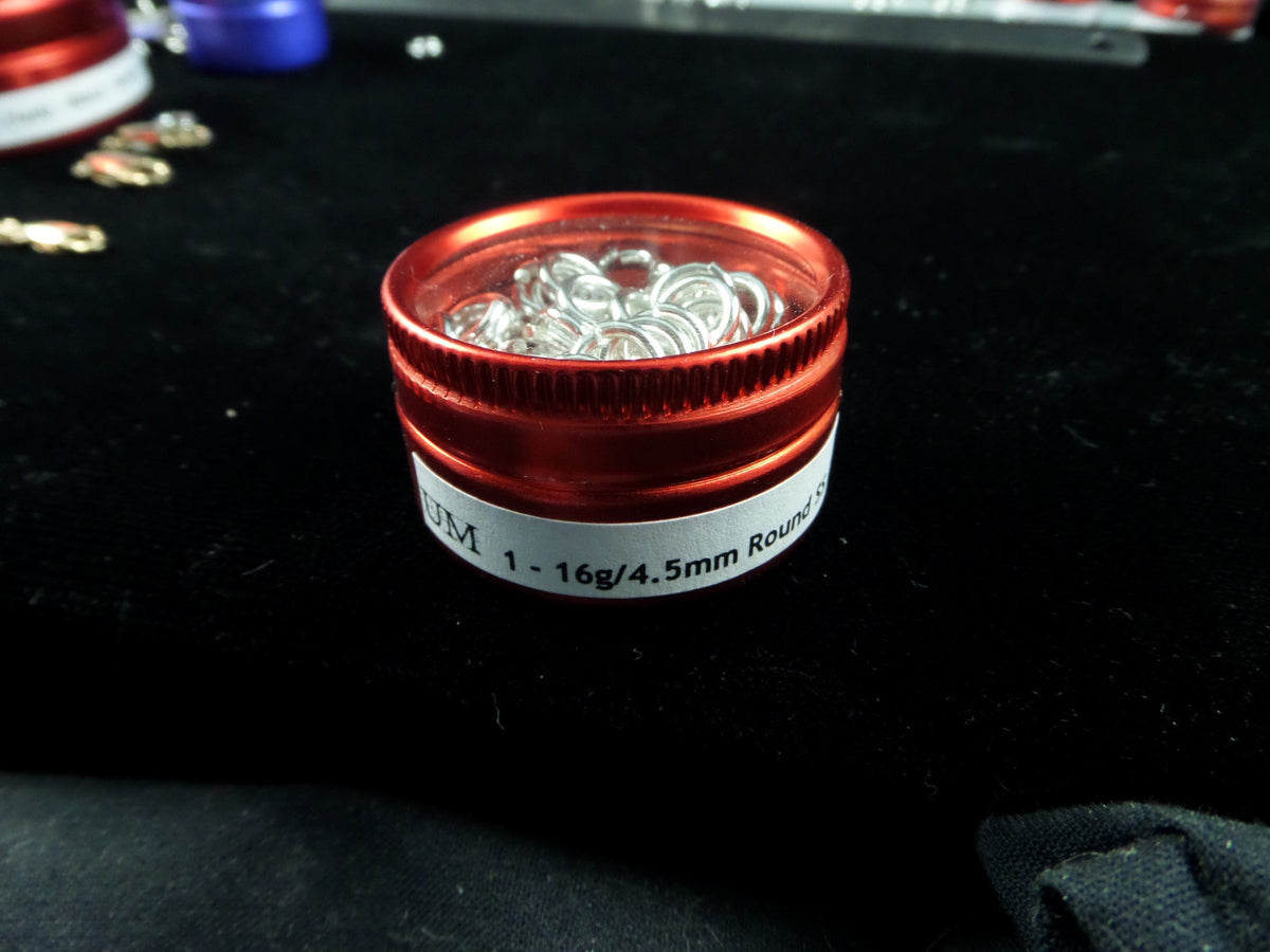 Round glass top tin filled with jump rings