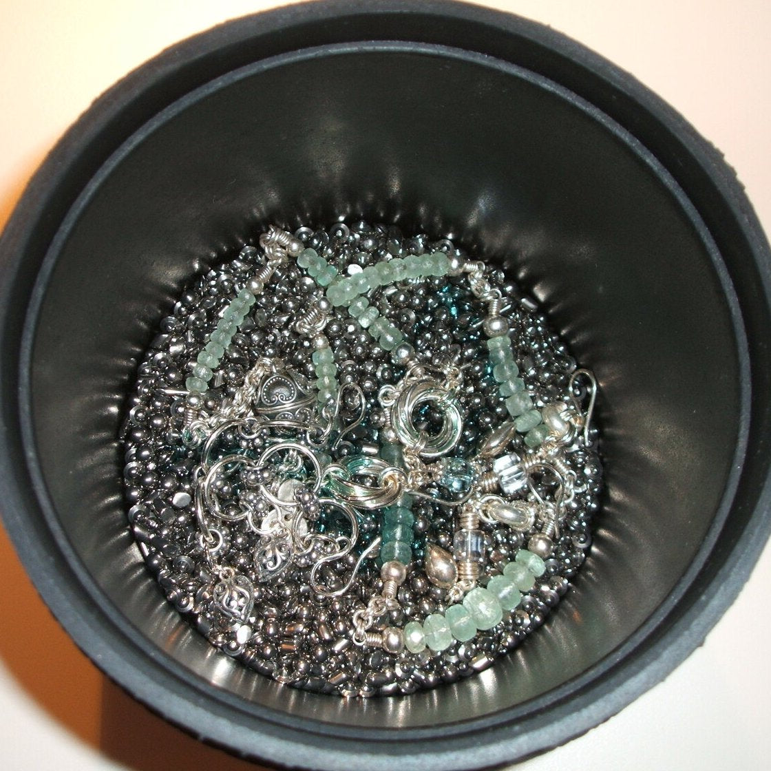 This tumbler barrel contains 2 pounds of mixed stainless steel shot, a necklace, several pair of earrings, and a healthy squirt of Dawn, maybe half a teaspoon or so. Use more for heavily tarnished jewelry.